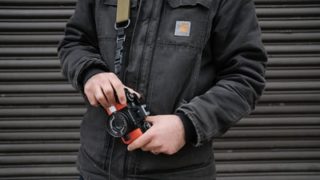 カメラを持つCarharttジャケットを着た男性