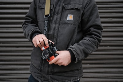 カメラを持つCarharttジャケットを着た男性